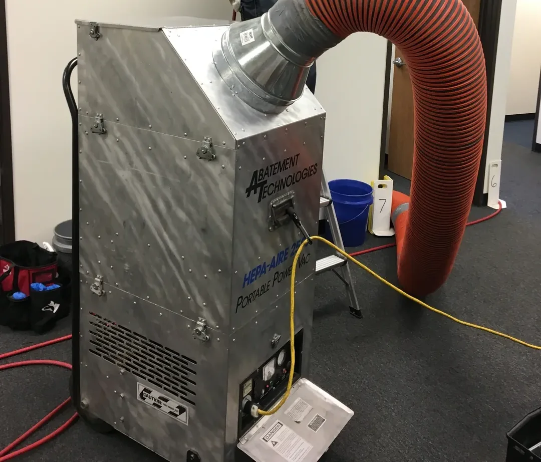 Abatement Technologies HEPA-AIRE portable power vacuum in use on a commercial duct-cleaning job